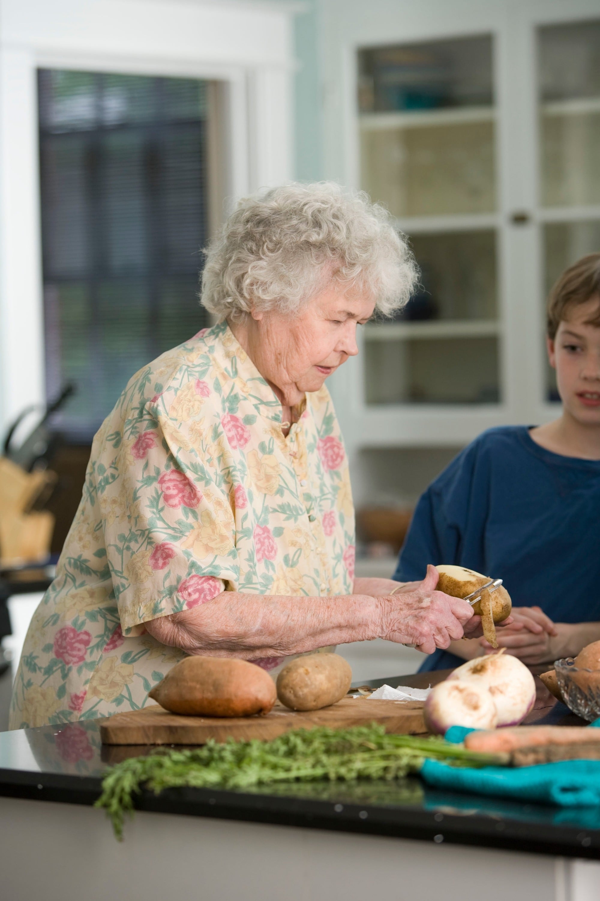 Elderly woman preparing food with assistance